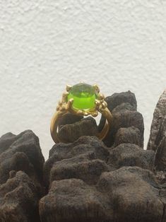 This is gold plated brass peridot ring. A designer handmade ring. It has a design of a coral, holding a green peridot gem. It could be an alternative engagement ring, or a great gift for a loving one. - 14 karat Gold plated brass - Round peridot gem - Free shipping worldwide - Sent in a gift box If you would like to see other rings I have made, please follow this link: https://www.etsy.com/il-en/shop/TamyZurTachshit?ref=seller-platform-mcnav&section_id=17271018 If you would like to go back t Green Fusion Rings For Formal Occasions, Modern Gold Rings With Stones, Modern Gold Jewelry With Peridot, Green Emerald Fusion Ring, Green Emerald Fusion Style Ring, Modern Gold Peridot Jewelry, Elegant Lime Green Ring For Gift, Elegant Lime Green Rings For Gift, Modern Green Peridot Jewelry