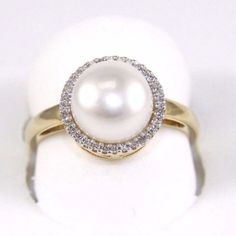 a pearl and diamond ring on a white surface