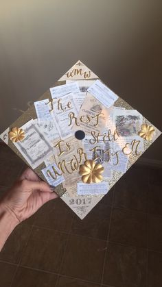 someone is holding up a graduation cap with gold foil decorations on it and the words congratulations