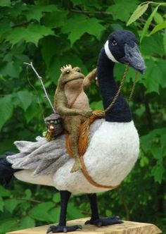 two stuffed animals sitting on top of a white duck with a black head and tail