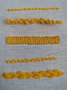 four different types of yellow thread on a white cloth