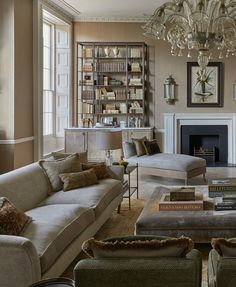 a living room filled with lots of furniture and a chandelier hanging from the ceiling