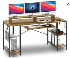 two computer monitors sitting on top of a wooden desk