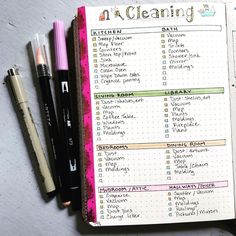 an open planner with writing on it next to two pens and a notebook that says cleaning