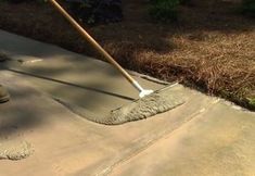 a person using a broom to clean concrete