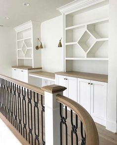 an instagramted photo of a kitchen with white cabinets and black iron railings