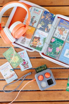 there are many books and headphones on the table next to each other, including children's books