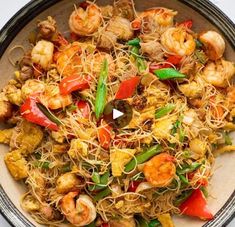 a bowl filled with shrimp and veggies on top of a table