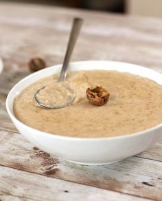 a white bowl filled with oatmeal on top of a wooden table