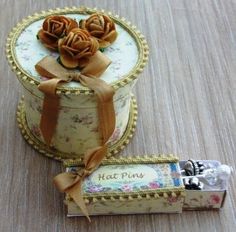 a small box that has some flowers on it and a ribbon tied around the top