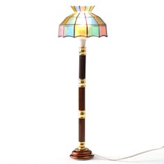 a lamp that is on top of a wooden stand with a white light behind it