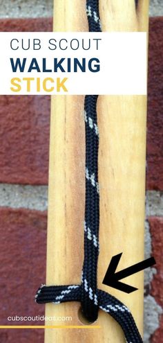 a close up of a wooden stick with an arrow pointing to the side and text that reads cub scout walking stick