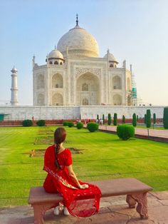 a woman sitting on a bench in front of the tajwa mosque, india