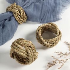 three pieces of rope sitting on top of a white table next to a blue scarf