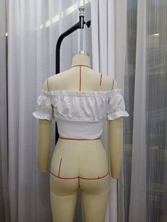 a mannequin wearing a white top with red trims on it's chest