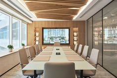 an empty conference room with white chairs and wooden walls, along with large windows overlooking the city