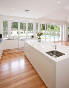 a large kitchen with white cabinets and wood flooring is seen in this image from the inside