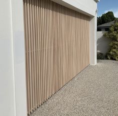 a garage door with vertical slats on the side of it in front of a house