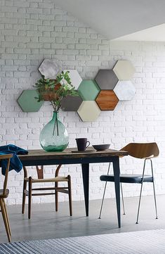 a dining room table with two chairs and a vase on the table next to it