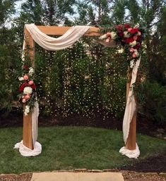 an outdoor wedding ceremony setup with flowers and greenery on the grass, surrounded by trees