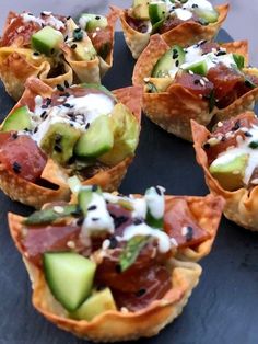 small appetizers with cucumbers and other toppings on a black plate