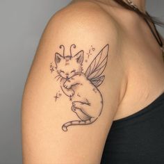 a woman with a tattoo on her arm holding a cat in the shape of a bee