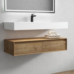 a bathroom sink with a mirror above it and towels on the counter top next to it