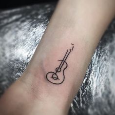 a small guitar tattoo on the wrist