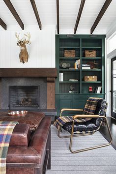 a living room with a couch, chair and bookcase in front of a fireplace