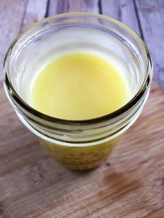 a glass jar filled with liquid sitting on top of a wooden table