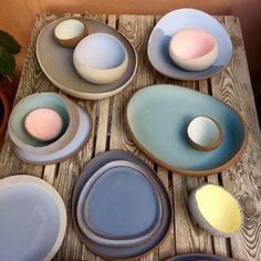 there are many plates and bowls on the wooden table with one egg in the middle