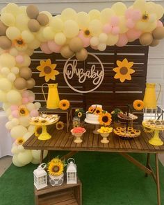 a table with sunflowers and balloons on it