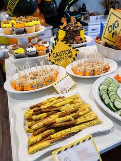 a table topped with lots of different types of food and desserts next to each other