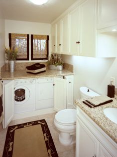 a washer and dryer in a bathroom with granite counter tops on the floor