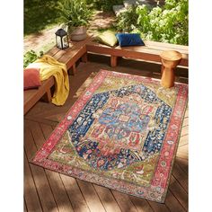 an outdoor area with benches, rugs and plants