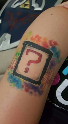 a person with a tattoo on their arm that has a question mark painted on it