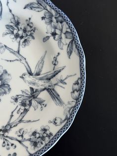 a blue and white plate with a bird on it's side sitting on a table