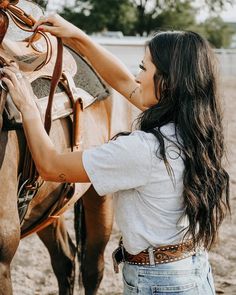 a woman is petting a horse on the nose