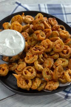 a plate full of fried onion rings with ranch dip