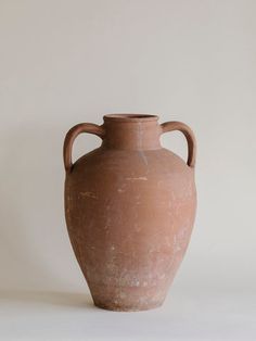 a large brown vase sitting on top of a white table