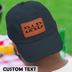 a man wearing a dad's hat with the word dad on it, sitting in front of a picnic table