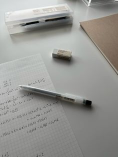 a pen sitting on top of a piece of paper next to a calculator