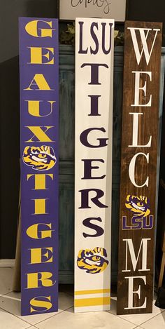 three wooden signs that say lsu and welcome