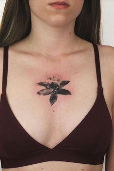 a woman with a flower tattoo on her chest