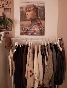 there is a poster on the wall next to some clothes hanging in front of it