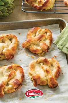 several pastries on a baking sheet with a pine cone in the background