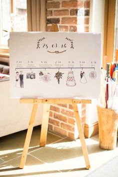 a white sign sitting on top of a wooden easel