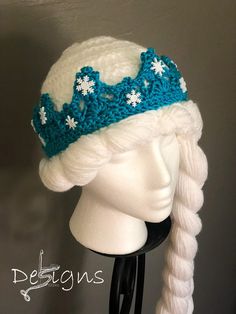 a crocheted hat with snowflakes on it sitting on a mannequin head