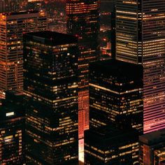 the city lights shine brightly at night in this aerial view from above, with skyscrapers lit up