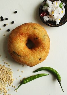 a donut and some rice on a white surface next to a bowl of food